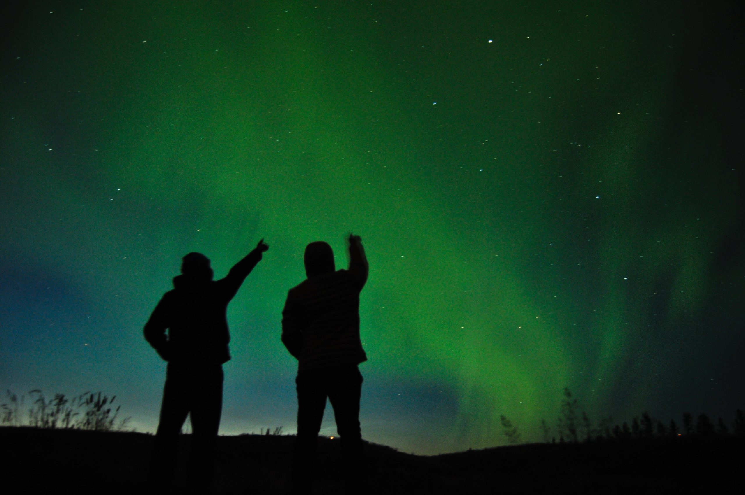 Two people look on the Northern Lights in Iceland