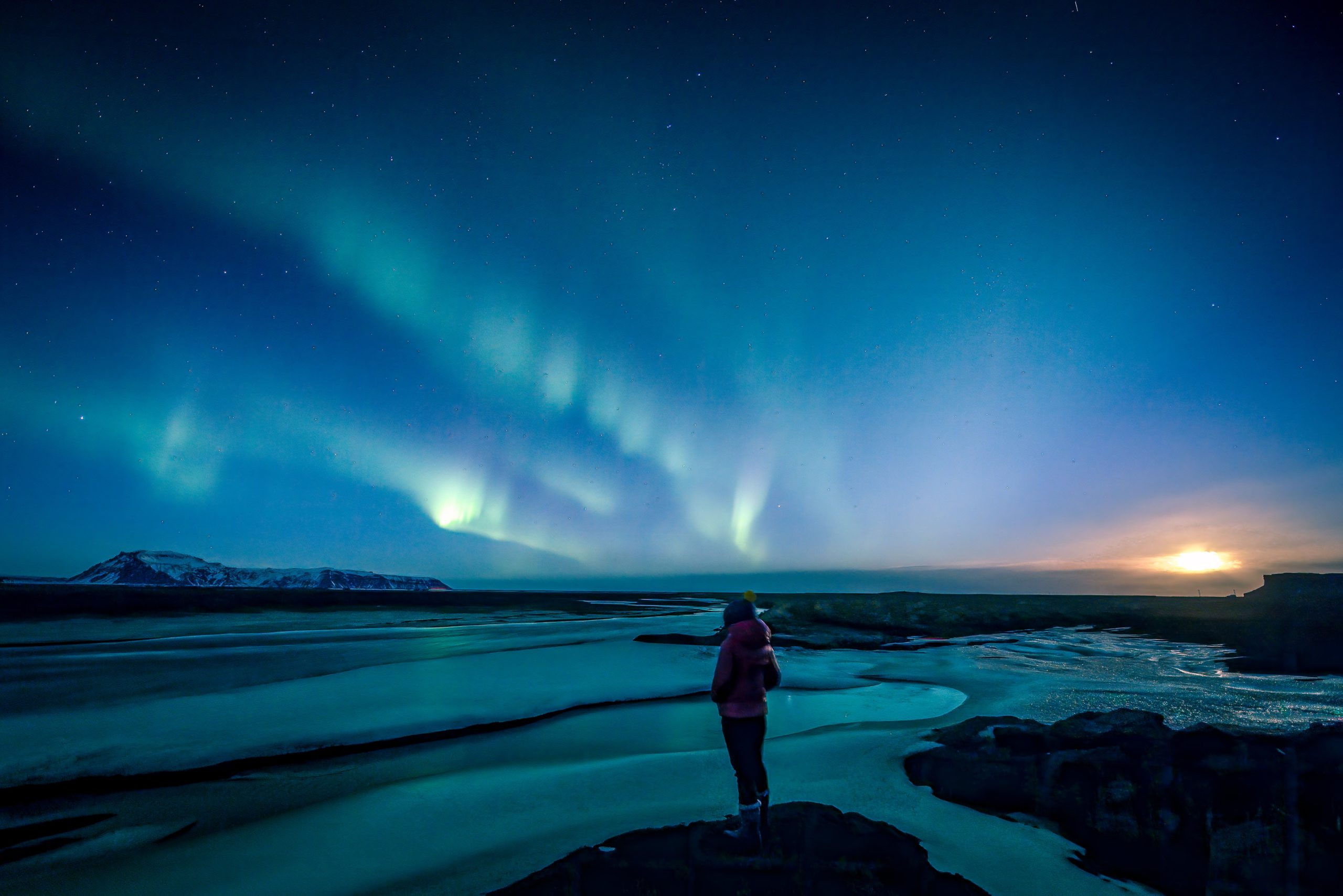 A girl looks at the Northern Lights in Iceland