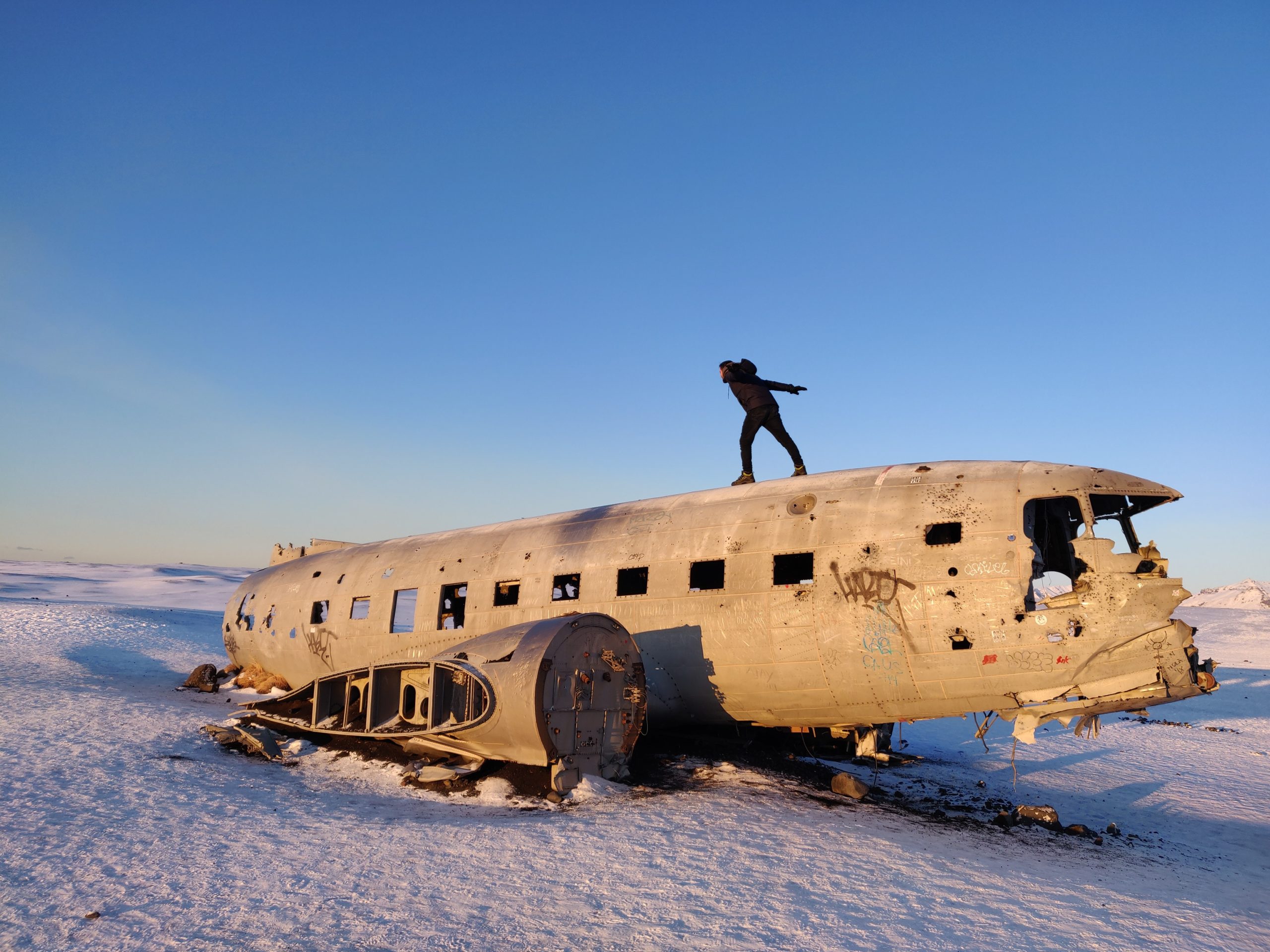 A man stands on top the plane wreck in Iceland