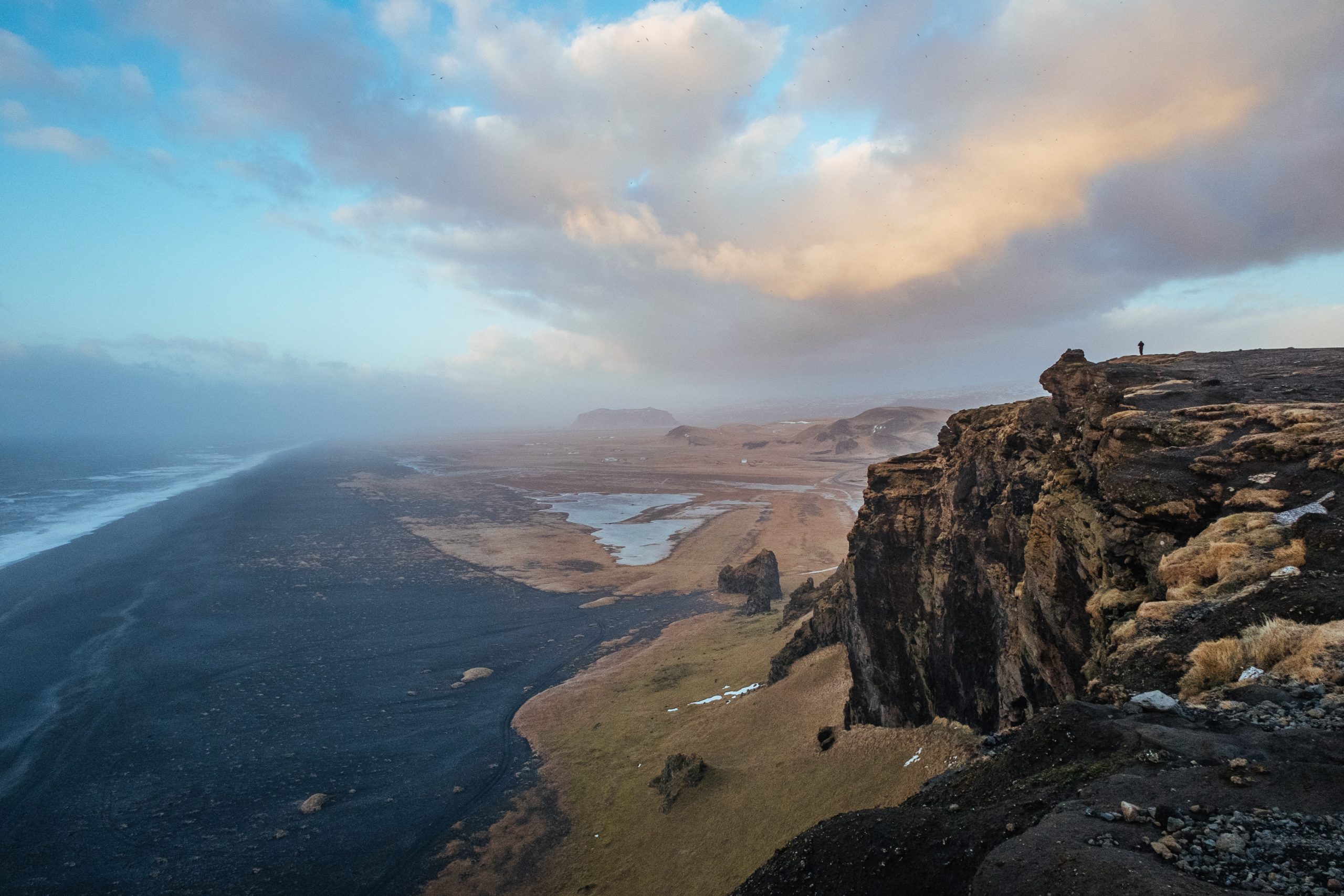 A man looks over the landscape from Dyrhólaey