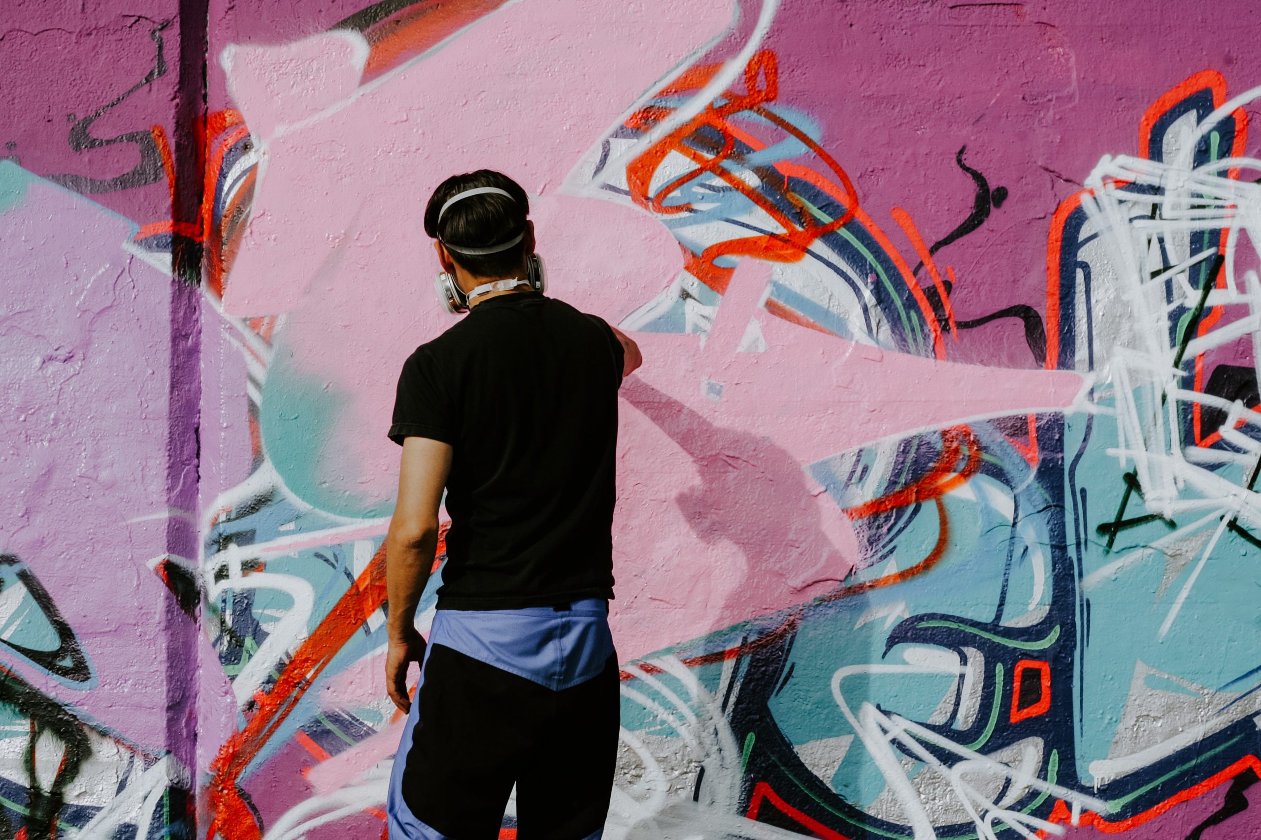 Person spray painting a wall